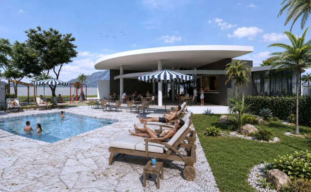 Piscina del club house con camastros y jardín