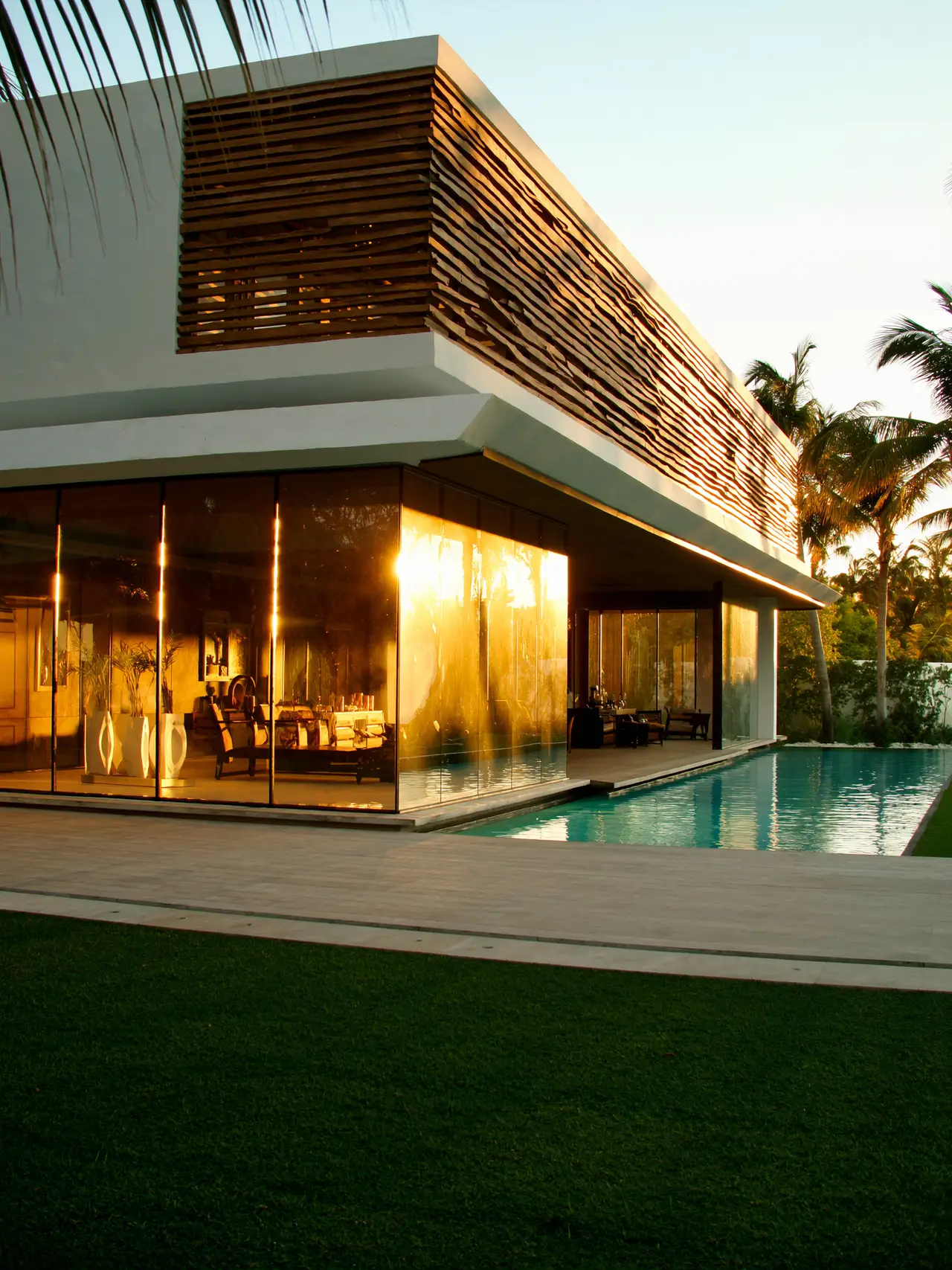 Villa moderna al atardecer con piscina y palmeras